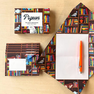 Pigeon stationery set with notebooks, pen, and packaging on a wooden surface
